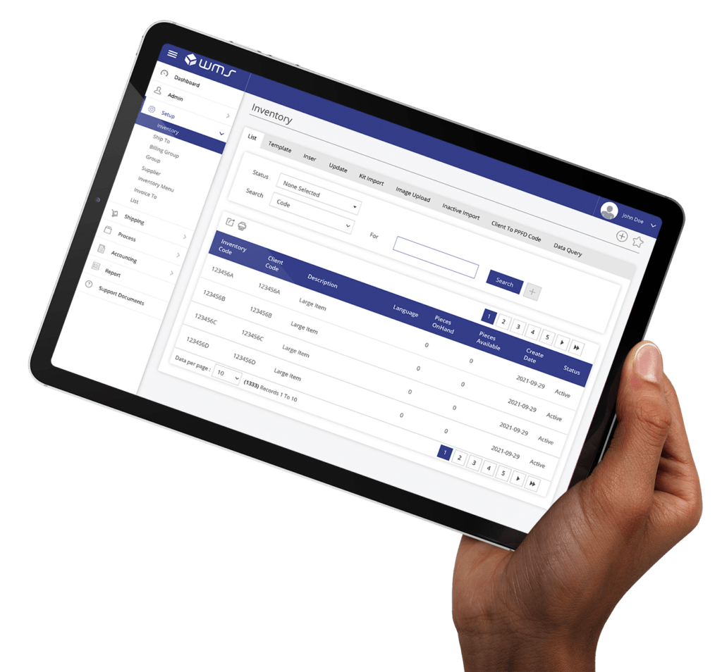 A close-up view of a hand holding a tablet displaying an inventory management system interface. The screen shows a detailed inventory list with columns for inventory code, client code, description, pieces on hand, pieces available, create date, and status. The user interface includes options for searching, filtering, and navigating through pages.